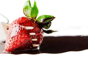 Strawberry on fork with  liquid chocolate on a white background.Horizontal image photo