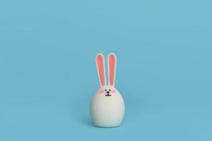 White rabbit with pink ears isolated on blue background. Copy space. photo