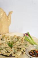 A traditional Javanese, Indonesian food made of tempeh coated with flour and half-fried green onions is called Tempe Mendoan photo