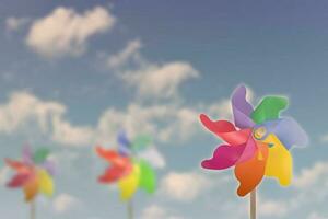 juguetes de molino de viento sobre fondo de nubes blancas de sol de cielo azul. foto