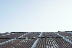 Old zinc rust roof and blue sky background photo
