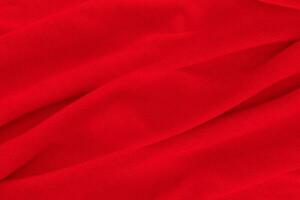 Red fabric texture background. Abstract cloth backdrop with soft waves. photo