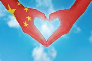 bandera china pintada en las manos en forma de corazón. foto