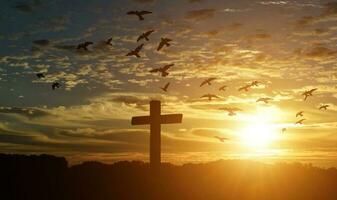 Silhouette of catholic cross at sunset background. photo