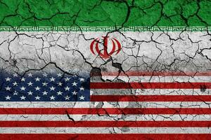 Flag of USA and Iran on cracked concrete wall background. Concept of Conflict between war America vs Iran photo