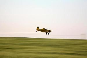 Cropduster airplane spraying a Saskatchewan field photo