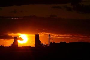 puesta de sol detrás de dos elevadores de granos de saskatchewan foto