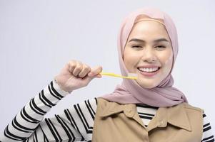 A young Muslim woman using toothbrush with beautiful teeth , Dental health care concept photo