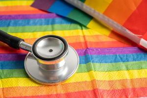 Black stethoscope on rainbow flag background, symbol of LGBT pride month  celebrate annual in June social, symbol of gay, lesbian, bisexual, transgender, human rights and peace. photo
