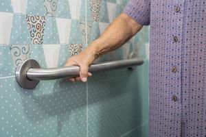 Asian senior or elderly old lady woman patient use toilet bathroom handle security in nursing hospital ward, healthy strong medical concept. photo