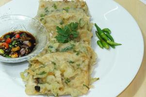 A traditional Javanese, Indonesian food made of tempeh coated with flour and half-fried green onions is called Tempe Mendoan photo