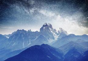 fantástico cielo estrellado. paisaje otoñal y picos nevados. dorsal caucásica principal. vista a la montaña desde el monte ushba meyer, georgia. Europa foto