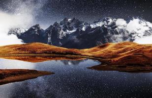 fantástico cielo estrellado en el lago de montaña koruldi. pintoresca noche superior svaneti, georgia europa. montañas del cáucaso foto