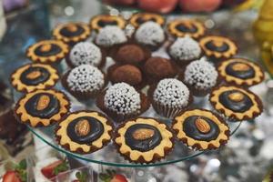 deliciosas galletas y pasteles coloridos en la barra de dulces de la boda. foto