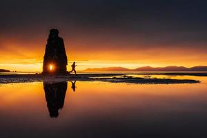 hvitserkur 15 m de altura. es una roca espectacular en el mar en la costa norte de islandia. en esta foto, hvitserkur se refleja en el agua del mar después de la puesta de sol de medianoche. foto