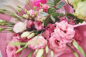 Beautiful bridal bouquet tied with silk ribbons and lace with a key in the form of heart. Roses and branches of an olive tree on the old vintage background photo