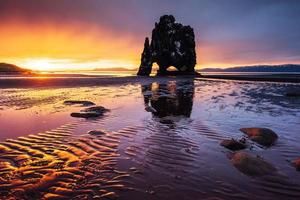 Is a spectacular rock in the sea on the Northern coast of Iceland. Legends say it is a petrified troll. On this photo Hvitserkur reflects in the sea water after the midnight sunset