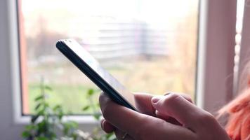 jeune femme utilise un téléphone portable intelligent à la maison - gros plan des mains video