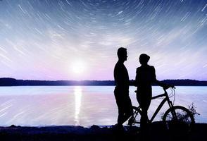 Couple on water background at night sky. Fantastic starry sky and the milky way.