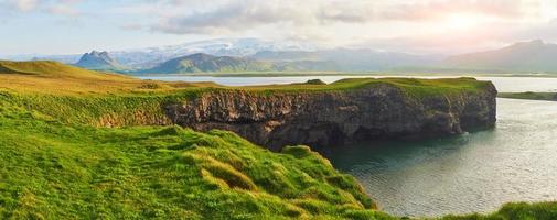 Cape Dyrholaey at southern Iceland. Altitude 120 m, and mean hill island with a door opening photo