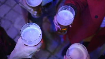 quattro amici insieme bevono birra in una strada notturna, persone multirazziali video