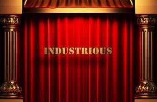 palabra dorada industriosa en cortina roja foto