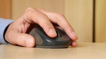 A Man use Computer Mouse clicking working on a Table - close-up video