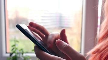 mujer joven usa teléfono móvil inteligente en casa - primer plano de las manos