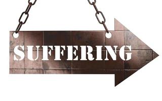 suffering word on metal pointer photo