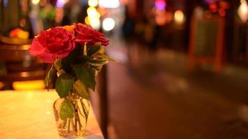 Blumen auf einem Tisch des Straßenrestaurants, Quartier Latin von Paris bei Nachtlichtern
