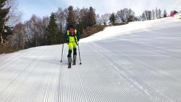 een kleine skiër bergbeklimmer klimt op de skipistes video