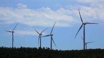 Wind turbines on a hill with blue sky and white clouds Tuscany Italy video