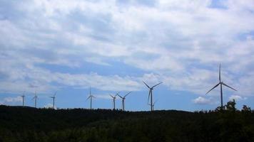 Wind turbines on a hill with blue sky and white clouds video