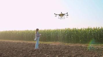 Smart Farmer mit Drohnen, die Dünger und Pestizide über Ackerland sprühen, Hightech-Innovationen und Smart Farming