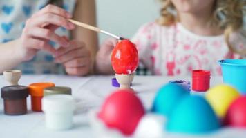 menina e sua mãe pintando ovos para a páscoa video