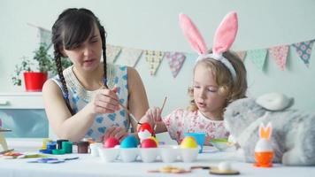 Little Girl with her Mother Coloring Easer Egg with Red Color video