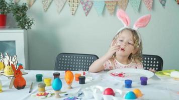 bambina che mangia l'uovo di Pasqua sbucciato. lei sorride e ride video