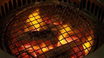 fuego en la estufa de barbacoa de carbón para asar alimentos con campana de humo. video