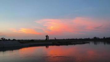 puesta de sol en la orilla del río. agua que fluye en el río en bangladesh. video