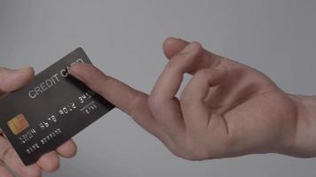 mano de hombre dando tarjeta de crédito a mano de mujer. fondo aislado. video