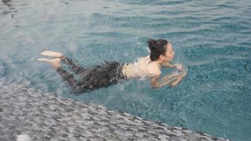 slow-motion shot, young Asian women swimming in rooftop pool, happy and relax time with swimming video