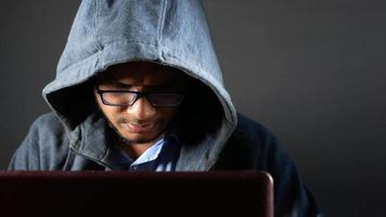 jovem trabalhando em um laptop roubando dados pessoais