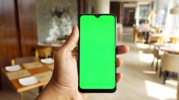 primo piano della mano del giovane che utilizza lo smartphone con lo schermo verde video