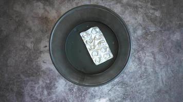 vista superior de pastillas y blisters en un contenedor video