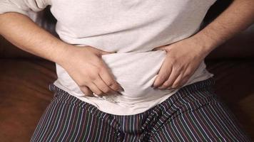 man's hand holding excessive belly fat, overweight concept video