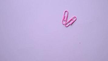colorful paper clip dropping on pink background .