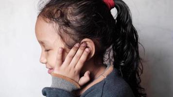 child girl having ear pain touching his painful ear ,