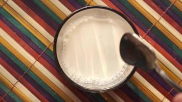 derramando leite no copo na mesa