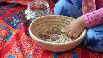 menina criança pilha moedas para economizar. sentado no chão