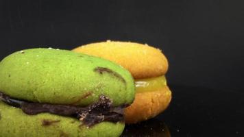 färgglada macaron fransk macaroon roterar på en svart bakgrund film video